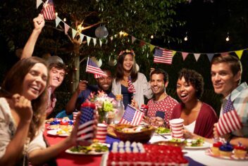 a party with young adults celebrating and holding small American flags
