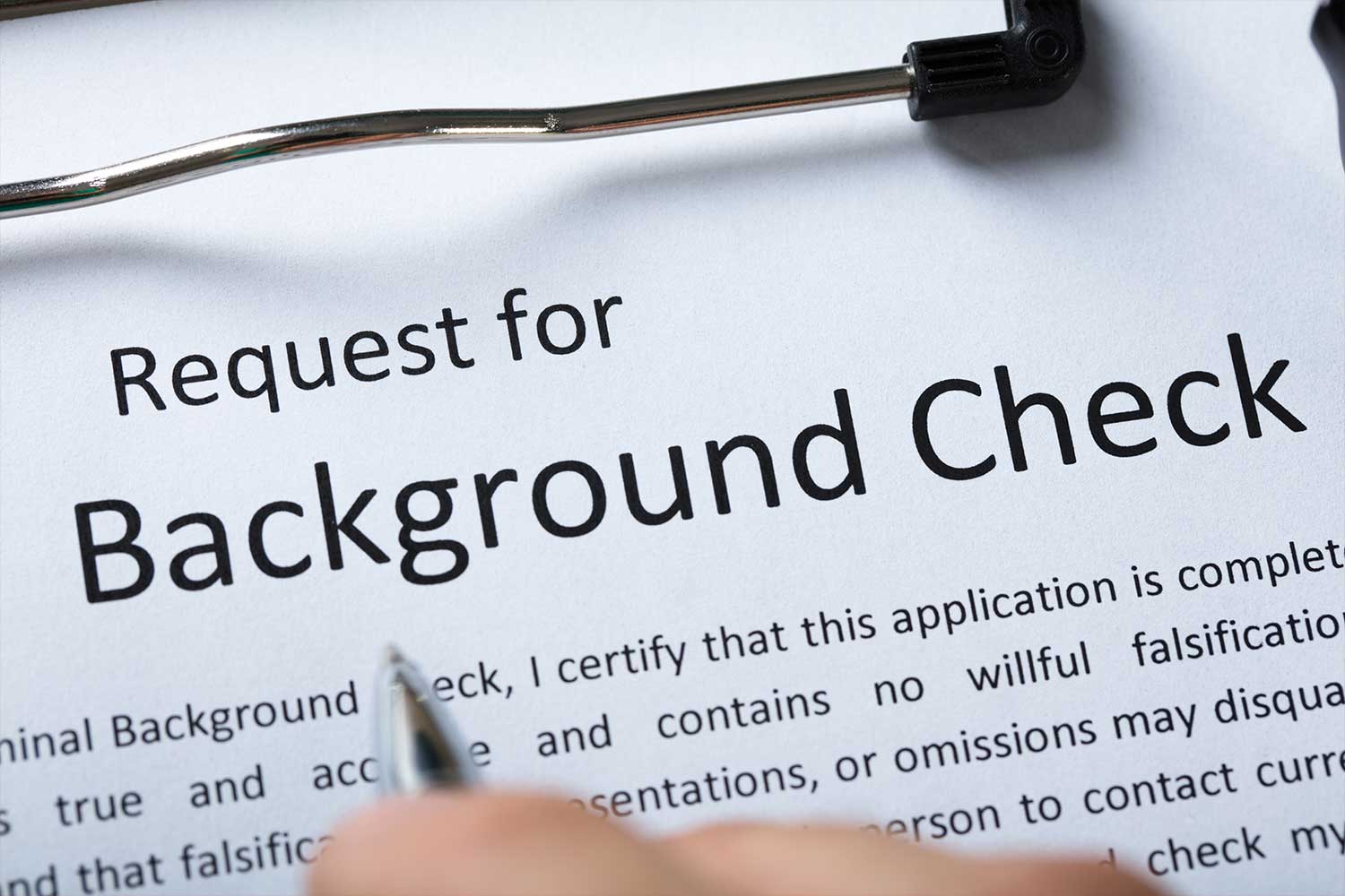 A sheet of paper on a clipboard stating "Request for Background Check"