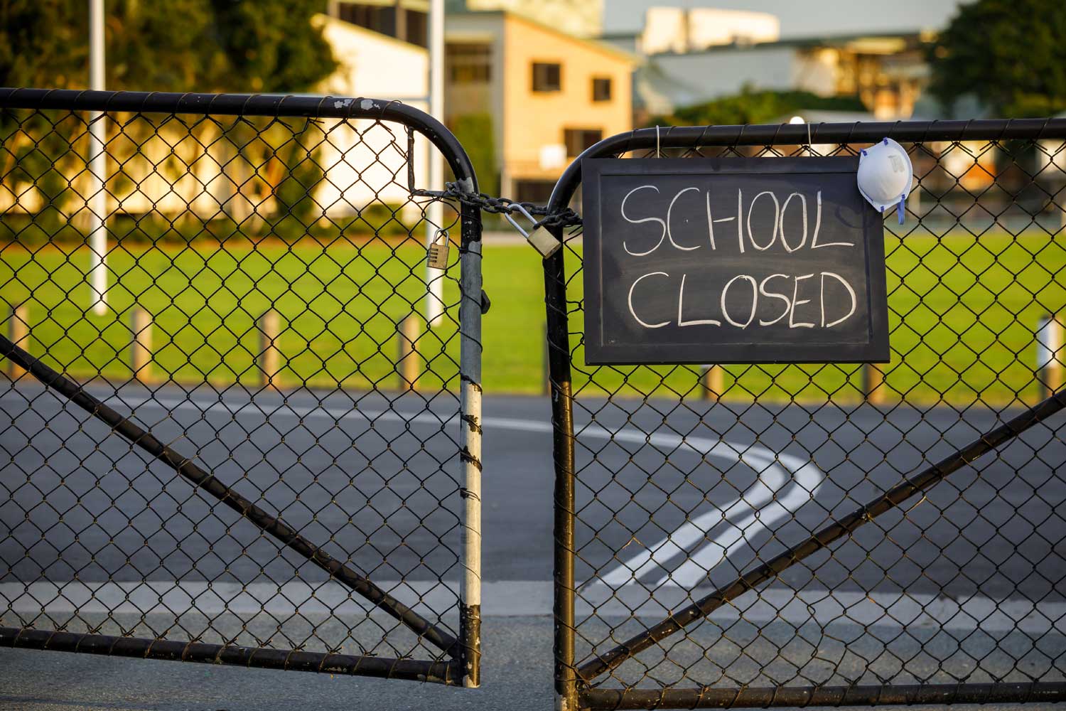 driveway with chain link fence and "school closed" sign