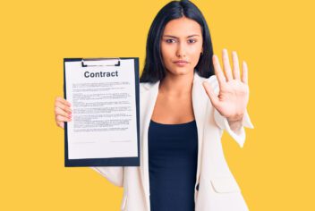 Young woman holding clipboard with contract document with open hand doing stop sign with serious and confident expression