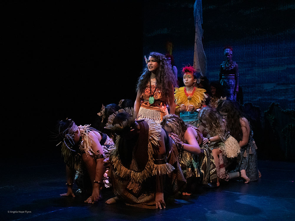 young actors grouped together on stage in native costumes 