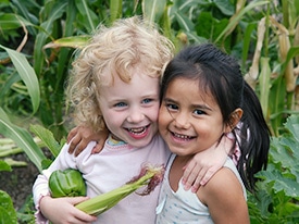 two young children with arms around each other posing for photo