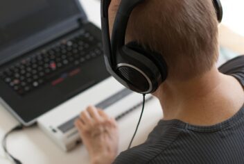 person with headphones on using a screen reader with a laptop