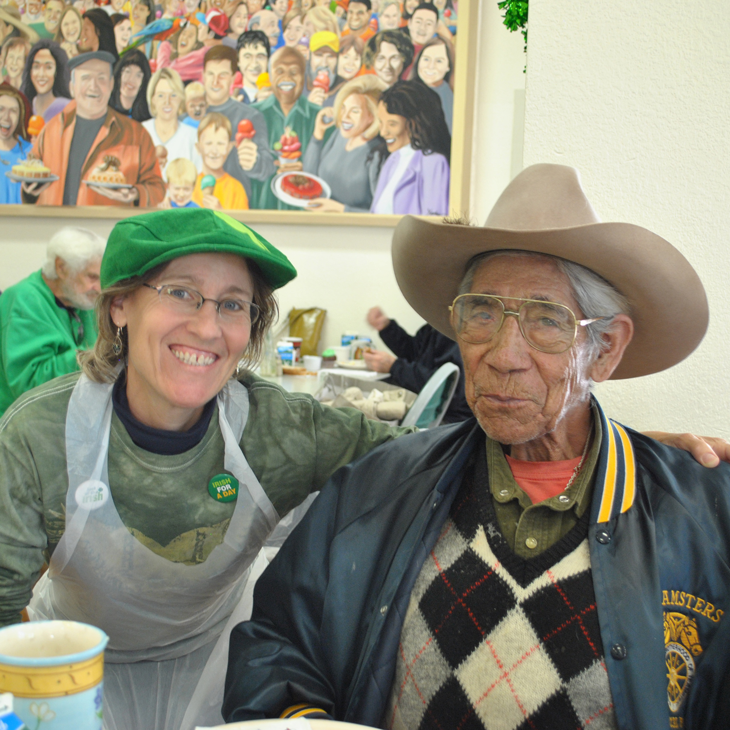 A volunteer server and a guest pose together at a free lunch for seniors put on by Community Bridges in Santa Cruz, CA