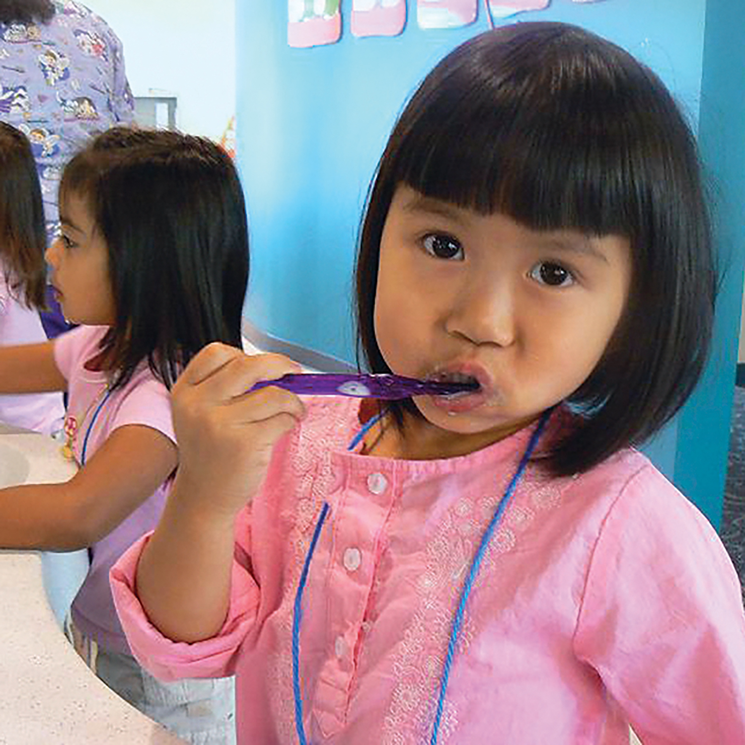 Young girls brush their teeth at Healthy Smiles of Orange County, CA