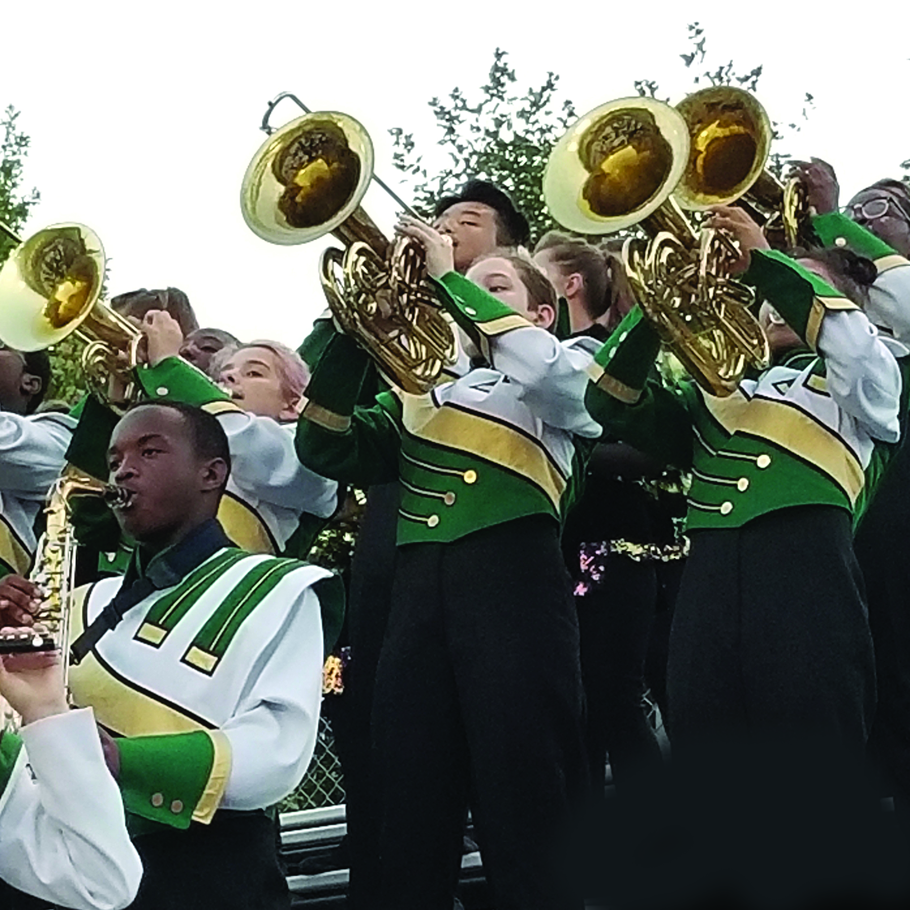 A high school band horn section plays in uniform