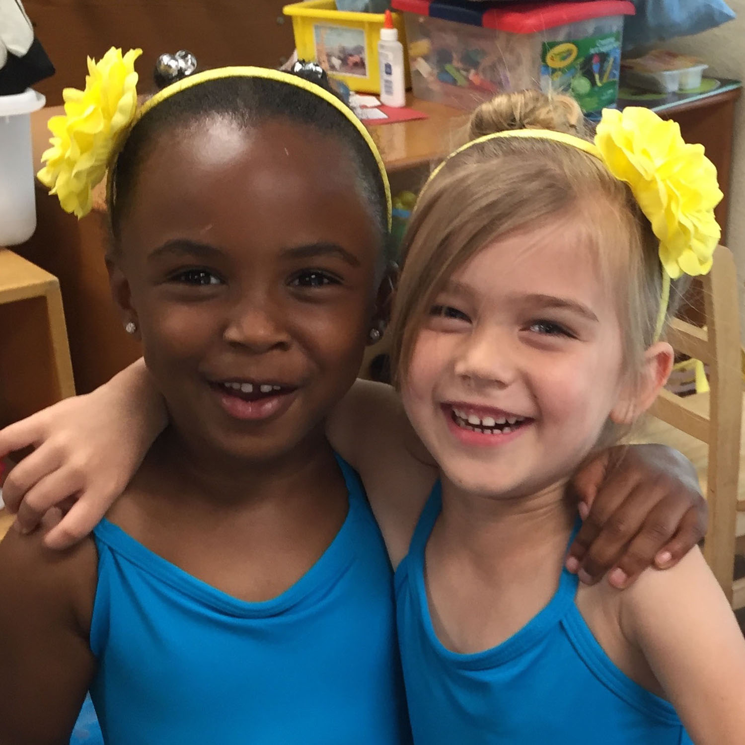 Two girls with matching headbands embrace and smile