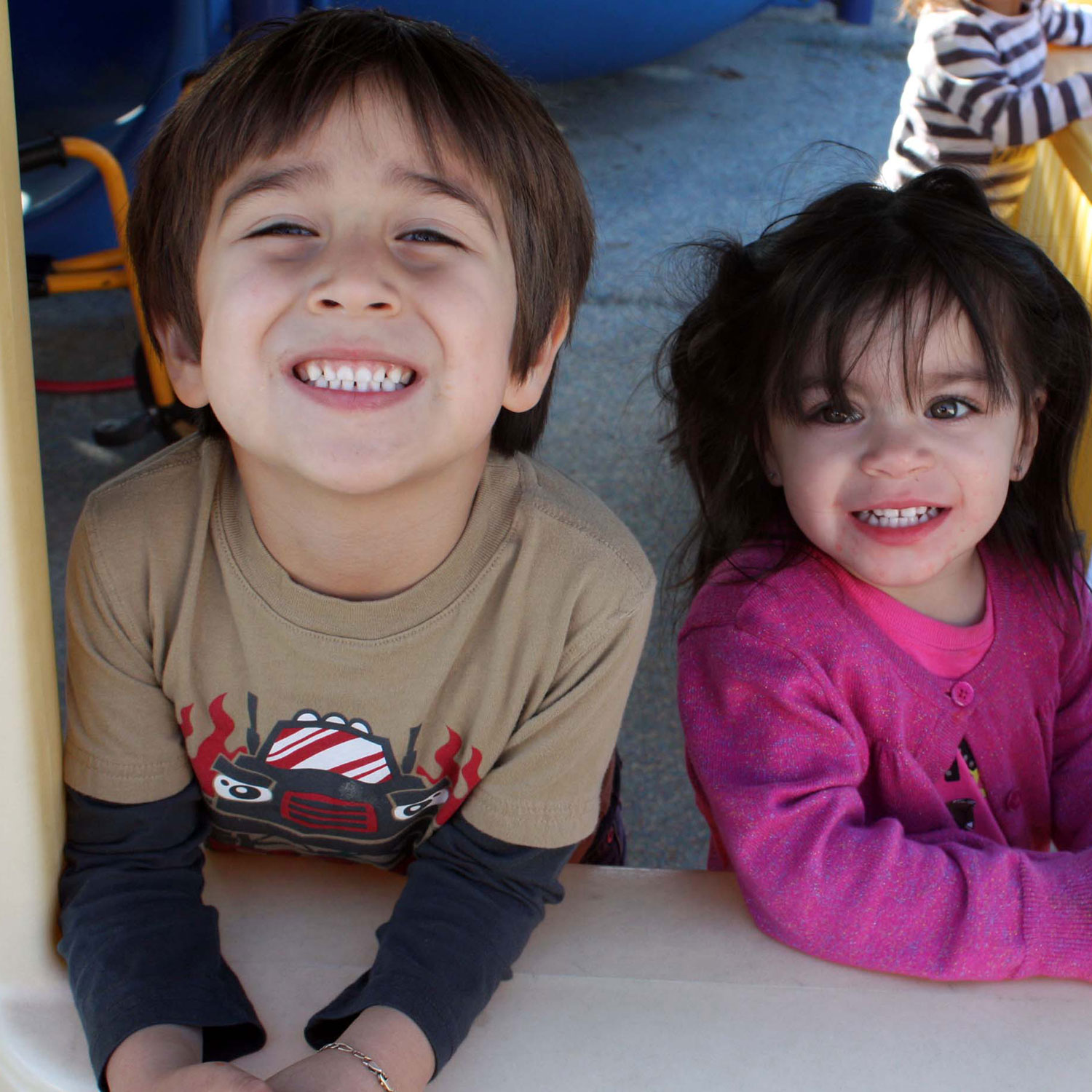 two smiling children on a play structure
