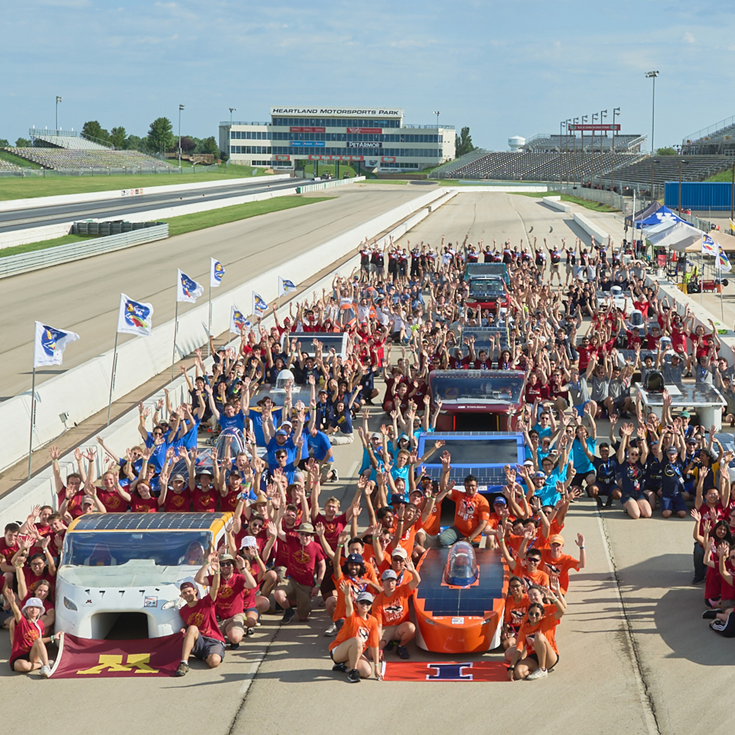 a large group of people and vehicles on a race track