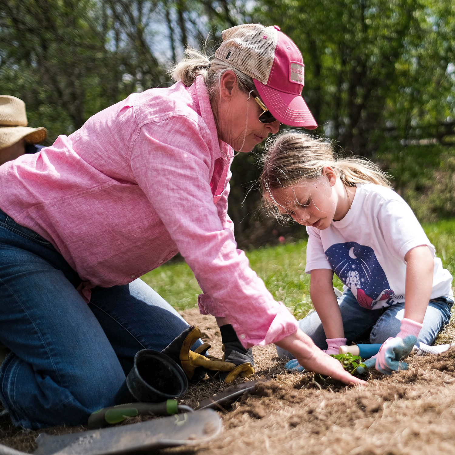 A woman and child planting something in the ground