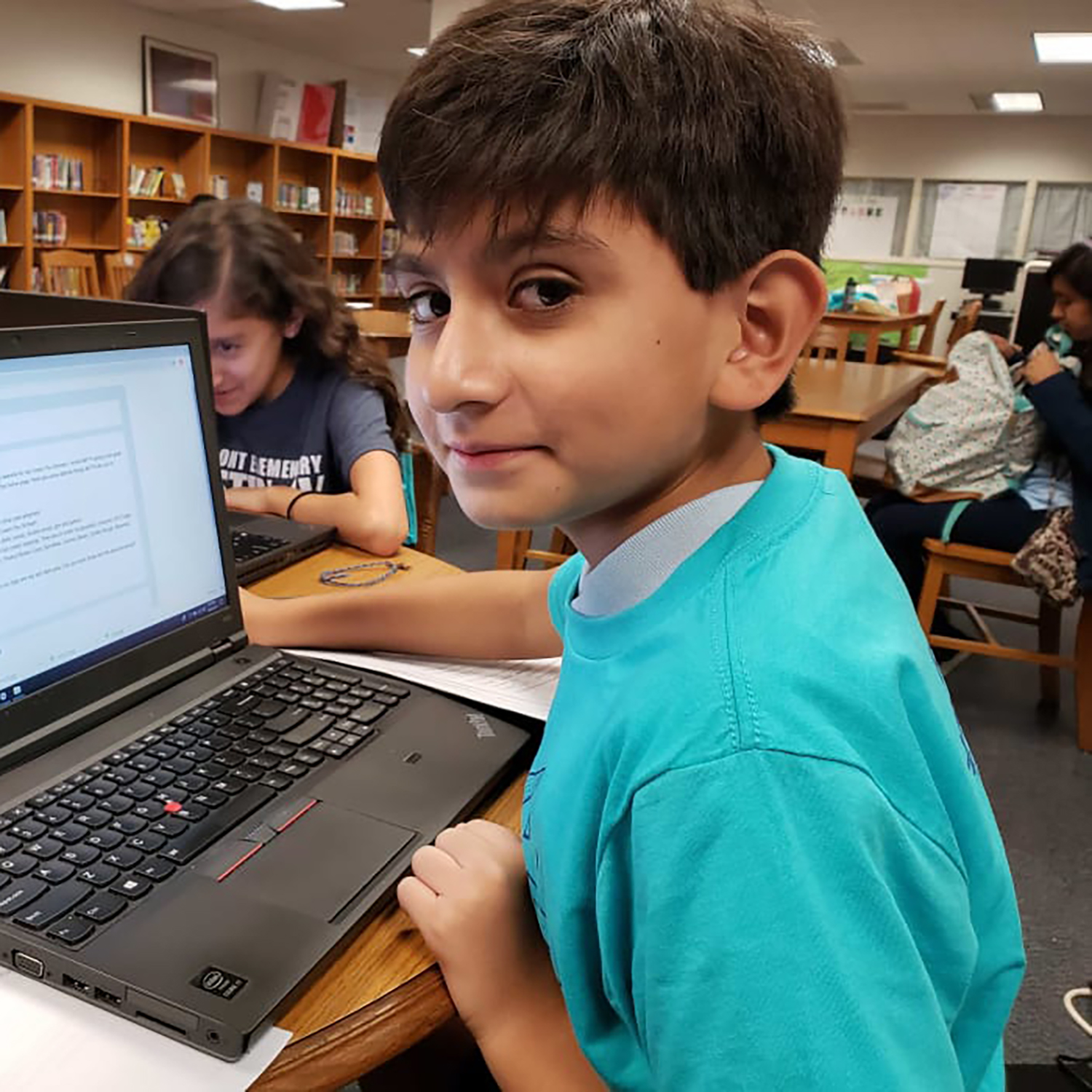 a boy in a library using a laptop