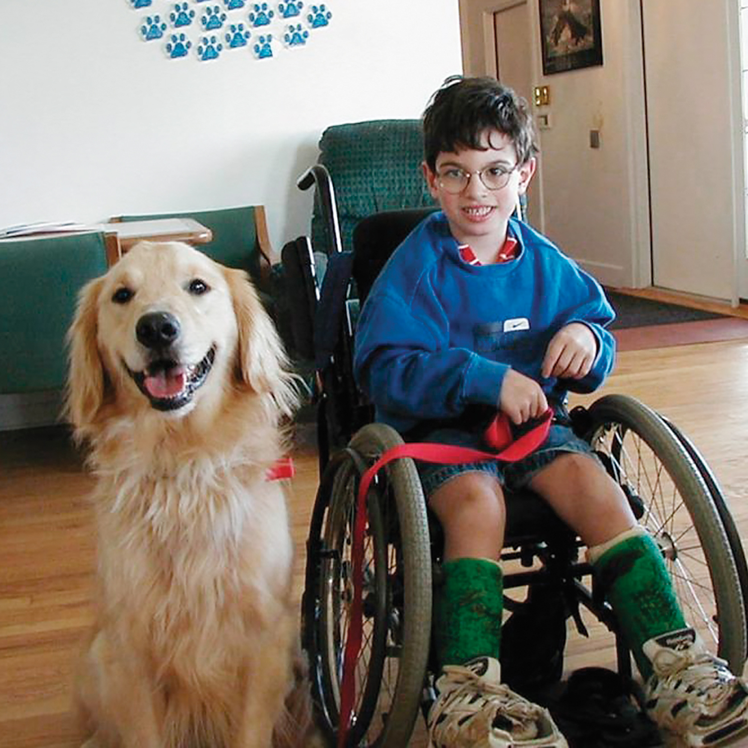a boy in a wheelchair poses with his service dog