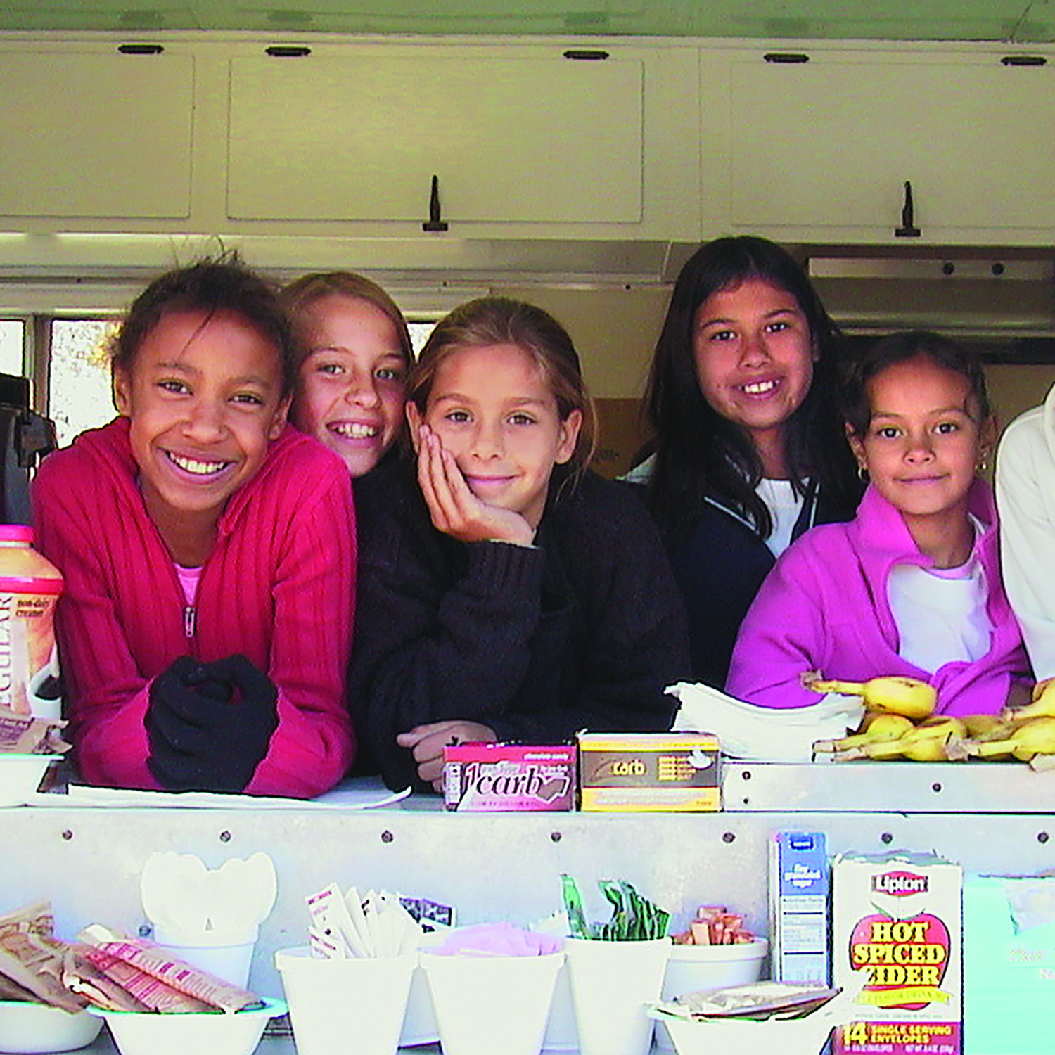 A group of kids behind the counter of a snack bar