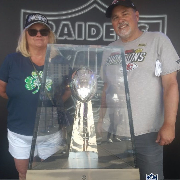 Rebecca B. and husband with football trophy