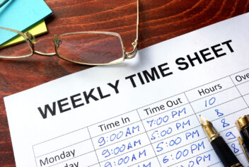 weekly time sheet with pen and glasses