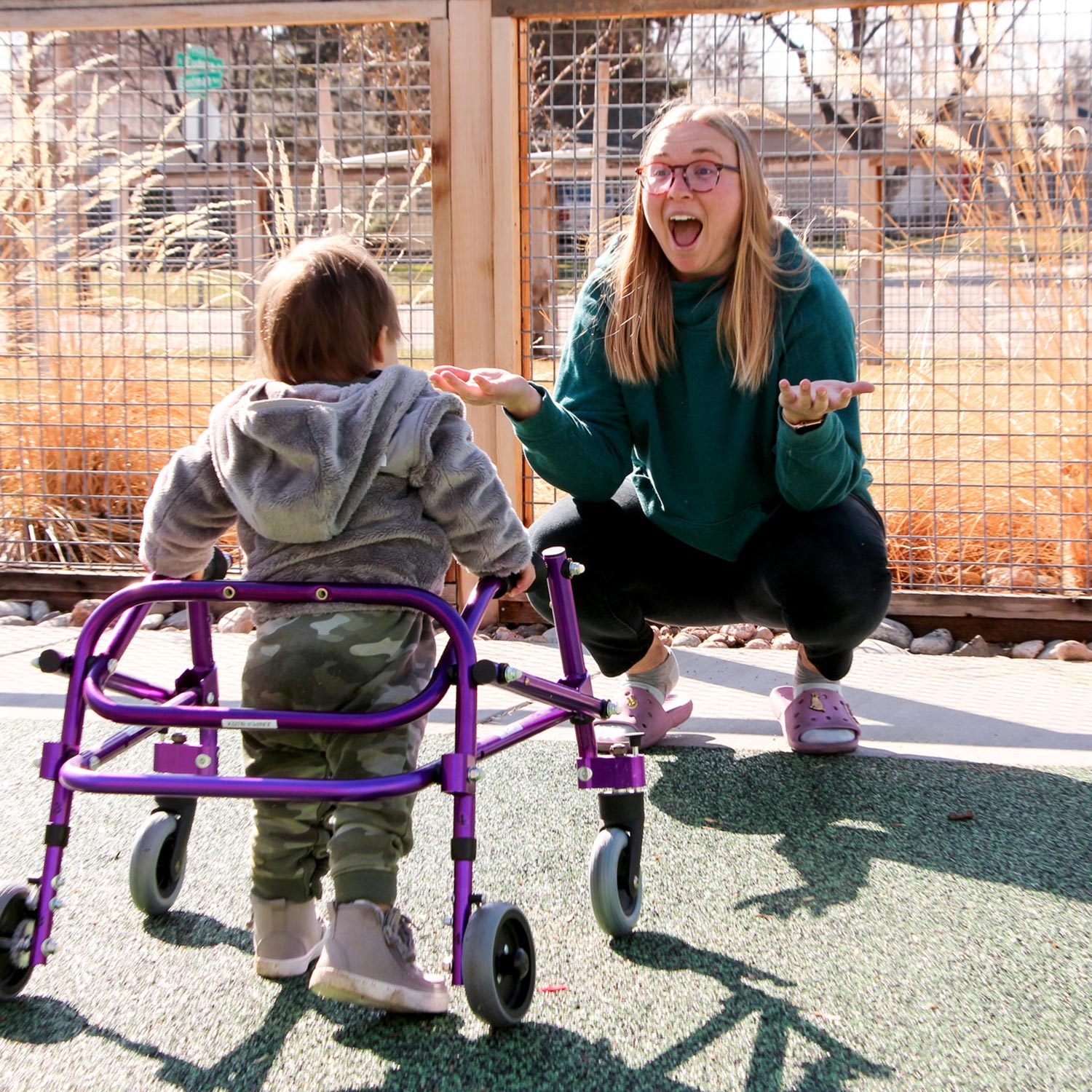 a child using a walker facing a young woman