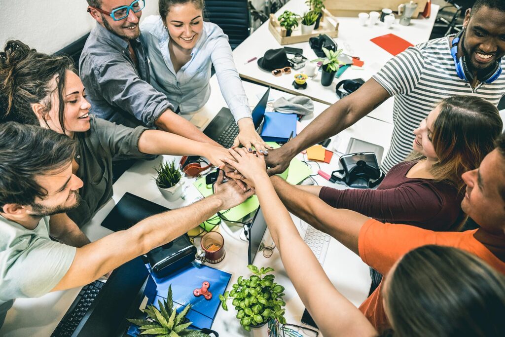 people sitting around a tabe doing a hand-pile