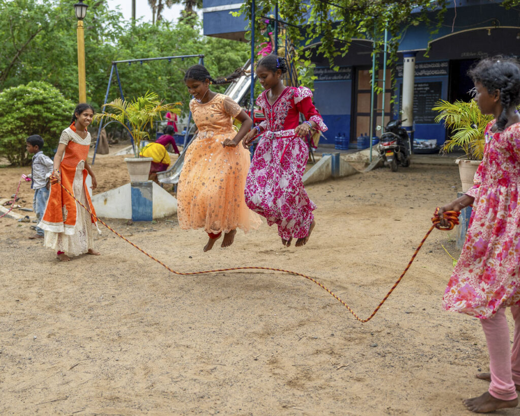 several girls jumping rope outside