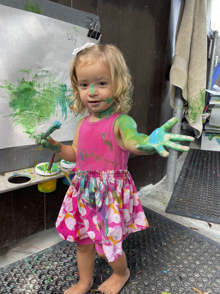 a toddler painting a picture