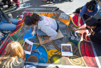 people working together to create sidewalk art