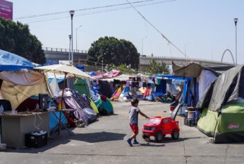 a small child playing with a red toy car
