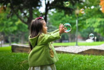 a young child chasing bubbles