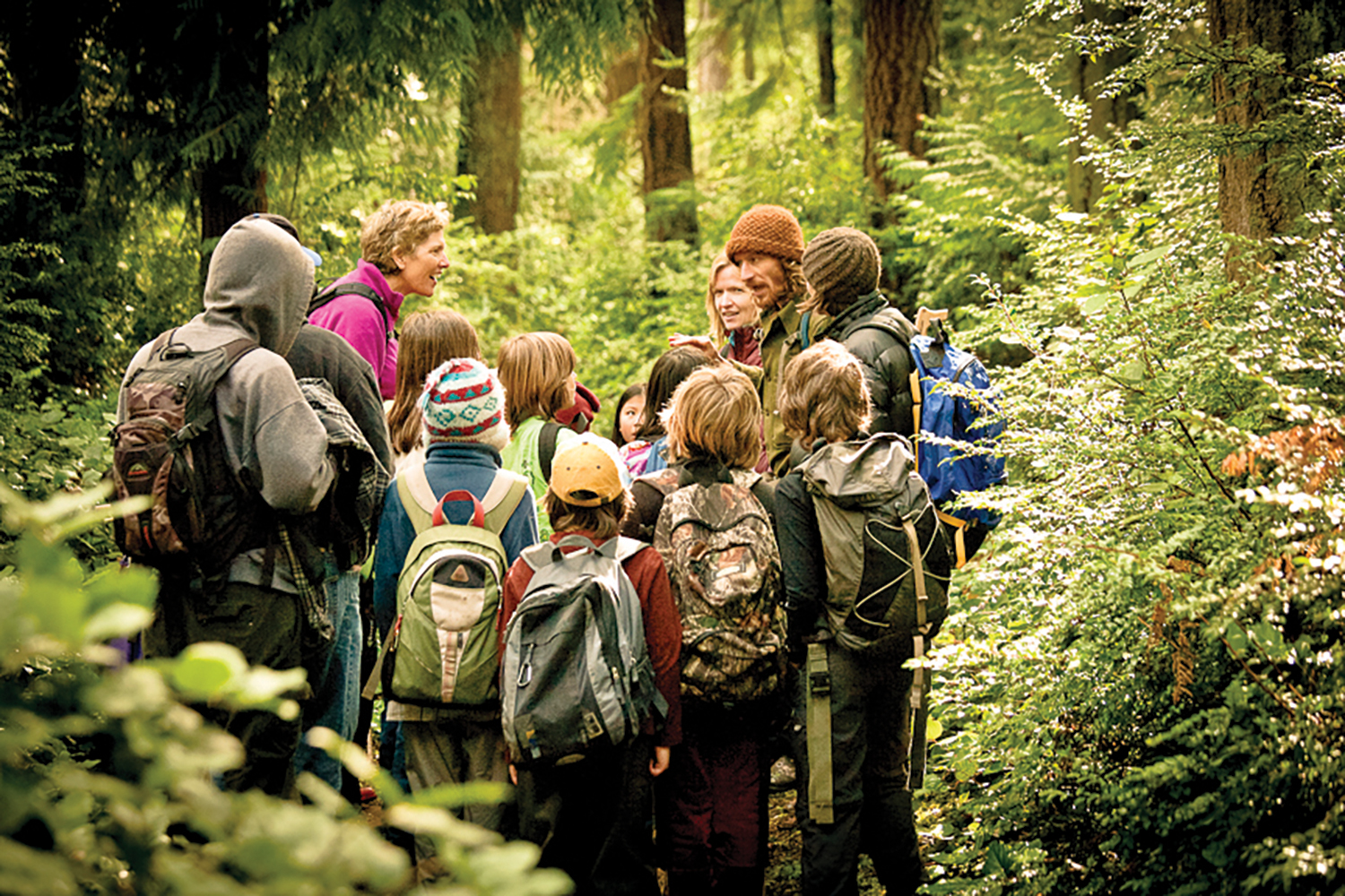 guides with a group of kids on a hike in a forest