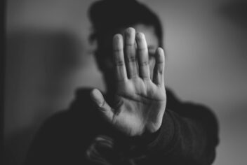 woman holding up hand to camera showing "stop"