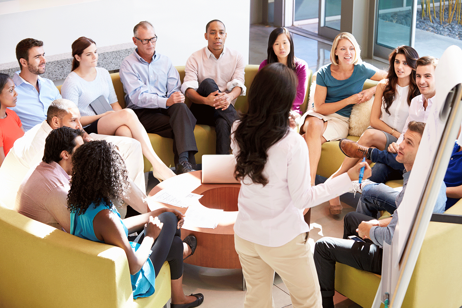 a group of adults listen while a person presents with a flip chart