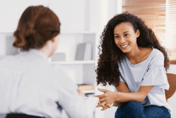 two woman sitting and talking