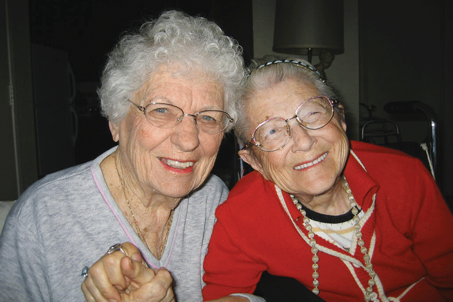 two women smiling and holding hands