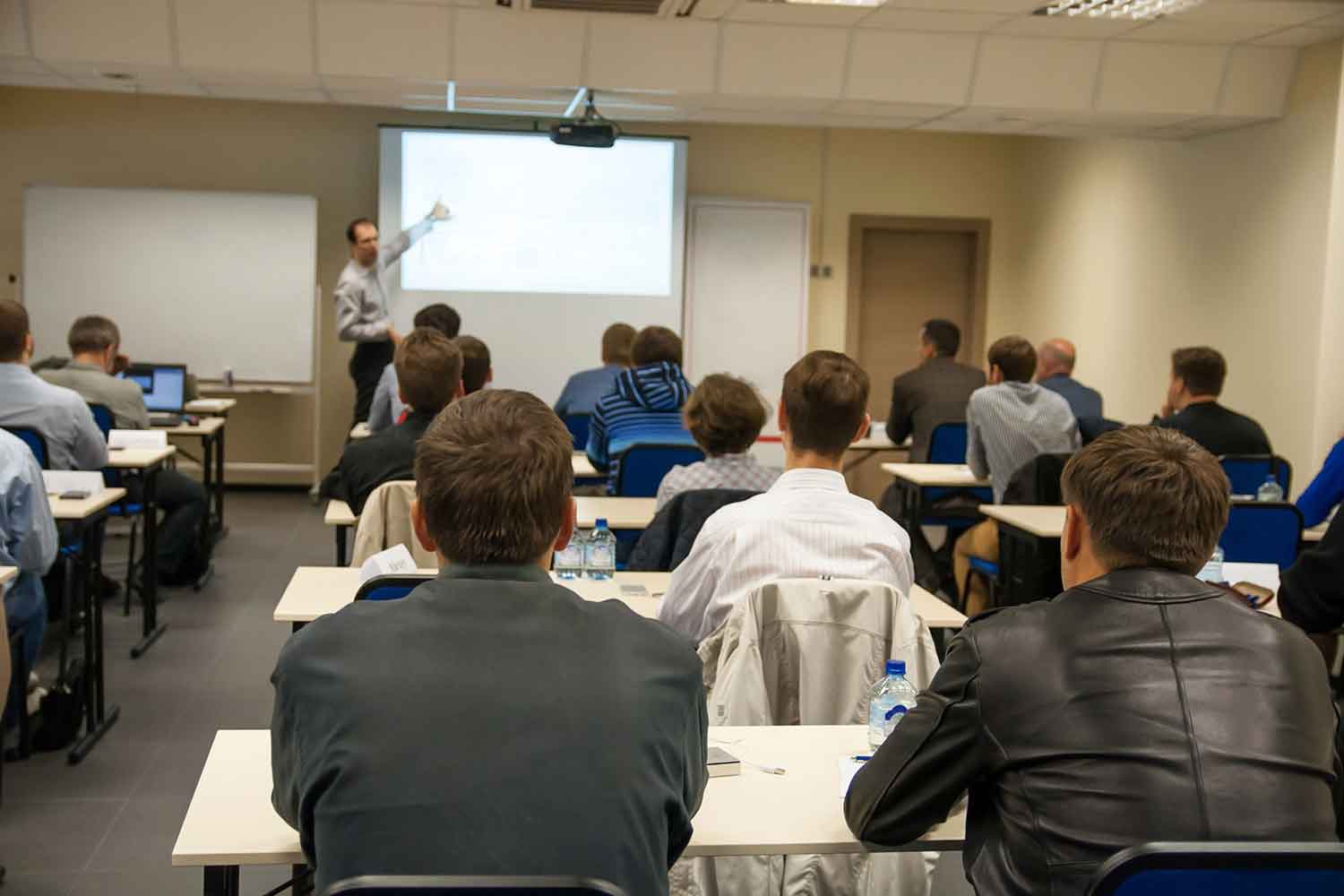 a group of adult students watching a classroom presentation