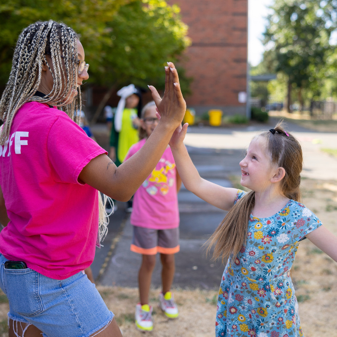 two people high-fiving outside