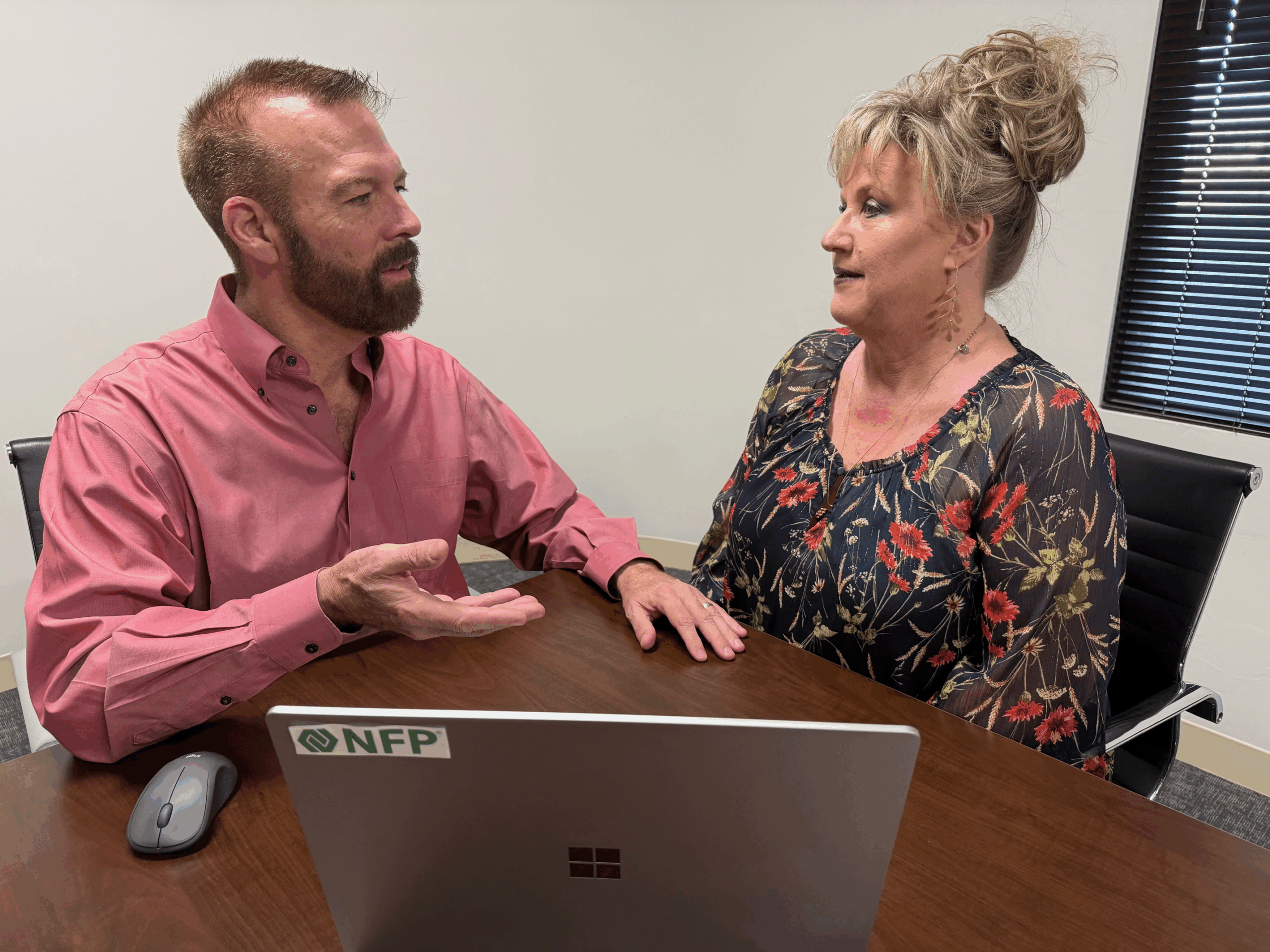 2 people sitting a table having a conversation