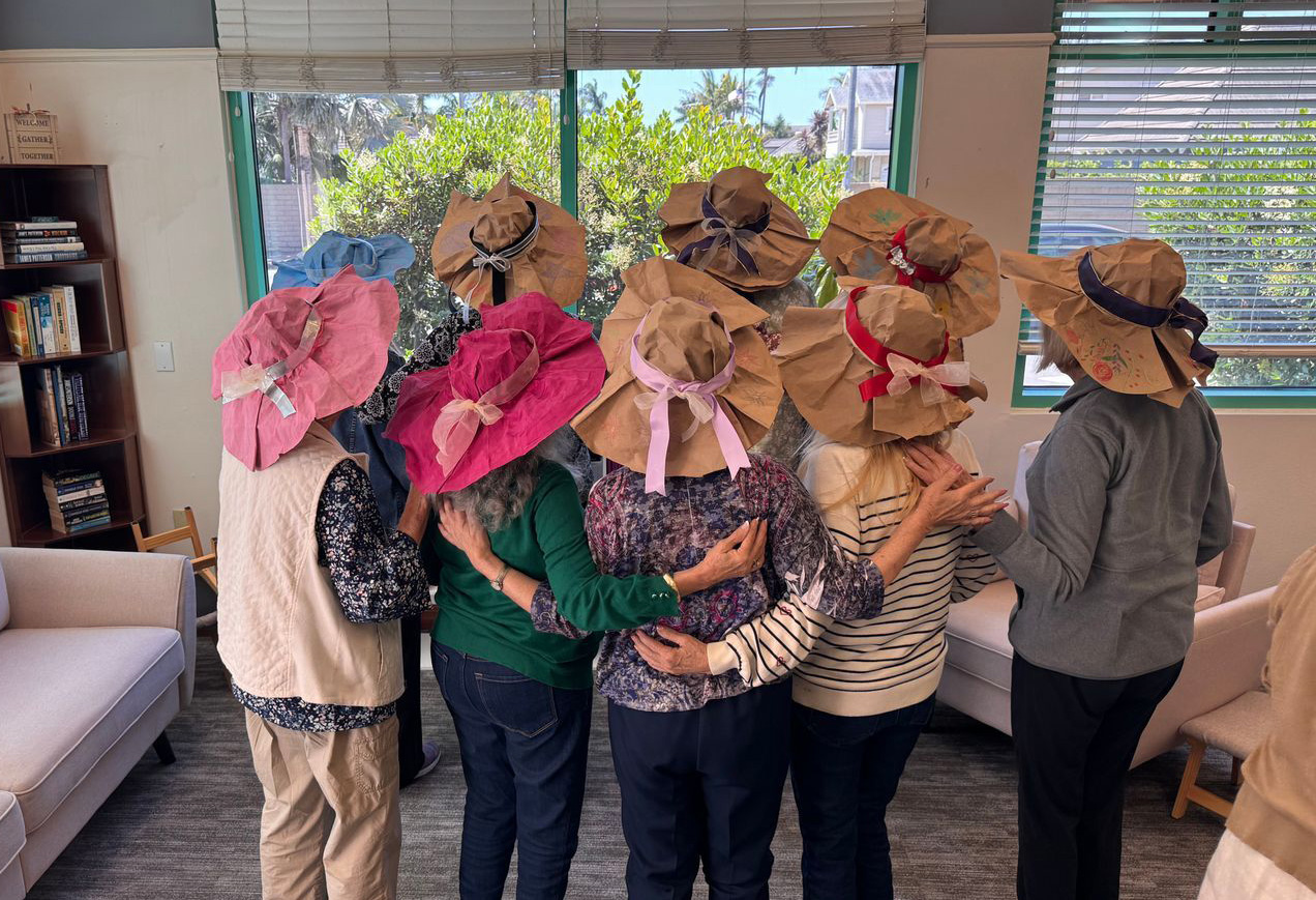 a group of women wearing handmade paper hats