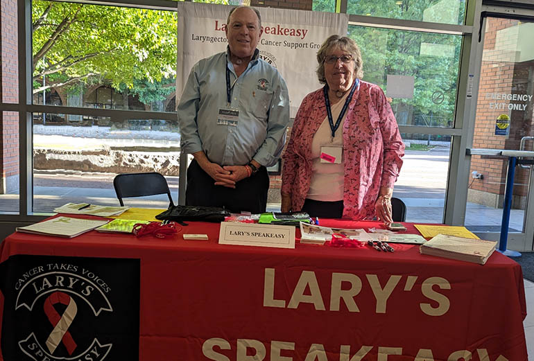 two people standing by an information table