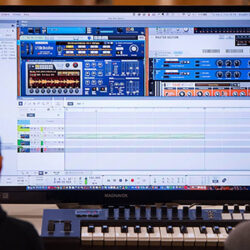 two people looking at a large audio control computer screen