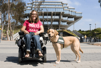 a woman with a service dog outside in front of a building