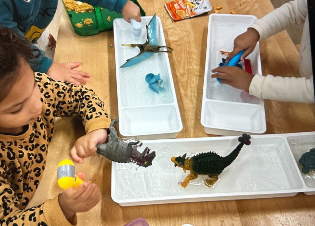 children playing with toy animals in water trays