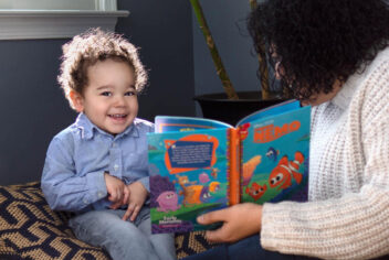 a person reading a book to a small child