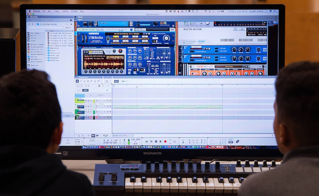 two people looking at a keyboard and computer monitor