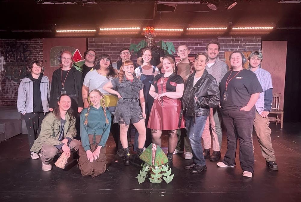 a group of performers pose in front of a stage set