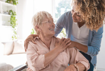 a woman helps another woman in a wheelchair