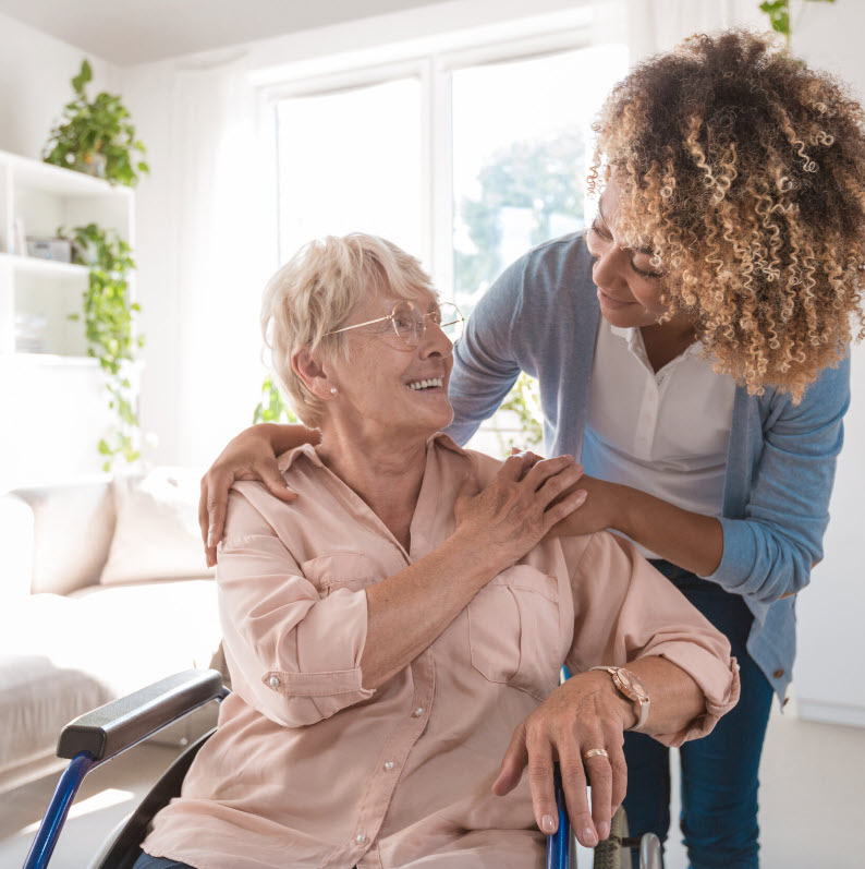 a woman helps another woman in a wheelchair