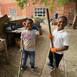 two people holding gardening tools outside