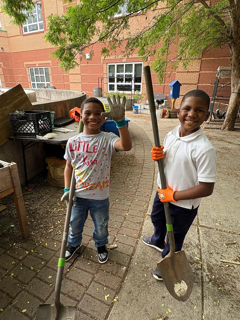 two people holding gardening tools outside