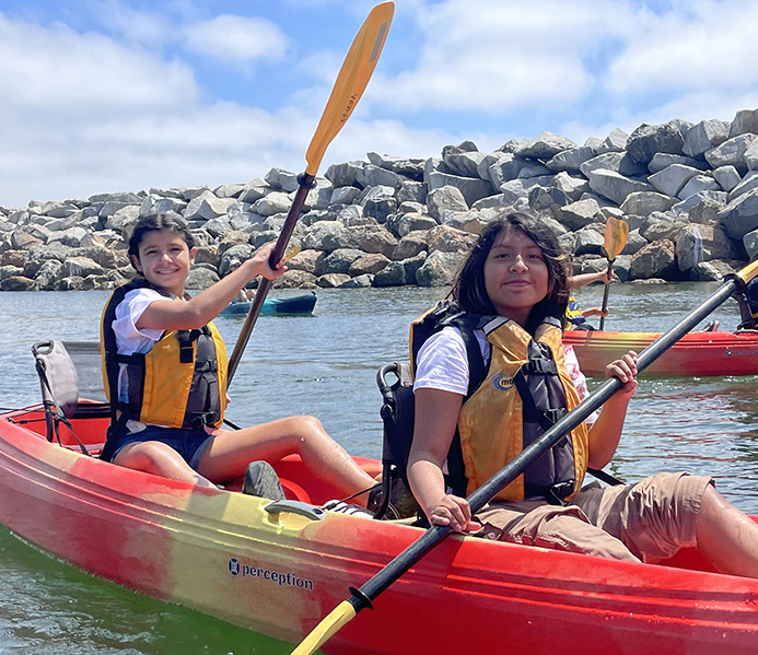 two people rowing a kayak