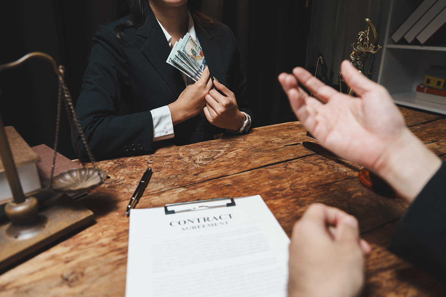 a person putting cash in their pocket at a business meeting