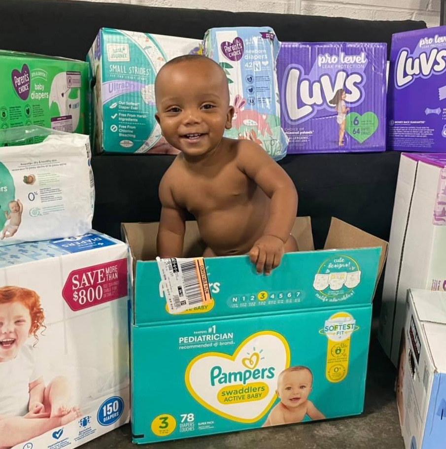 a baby standing in a diaper box