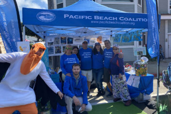 people standing under a blue tent